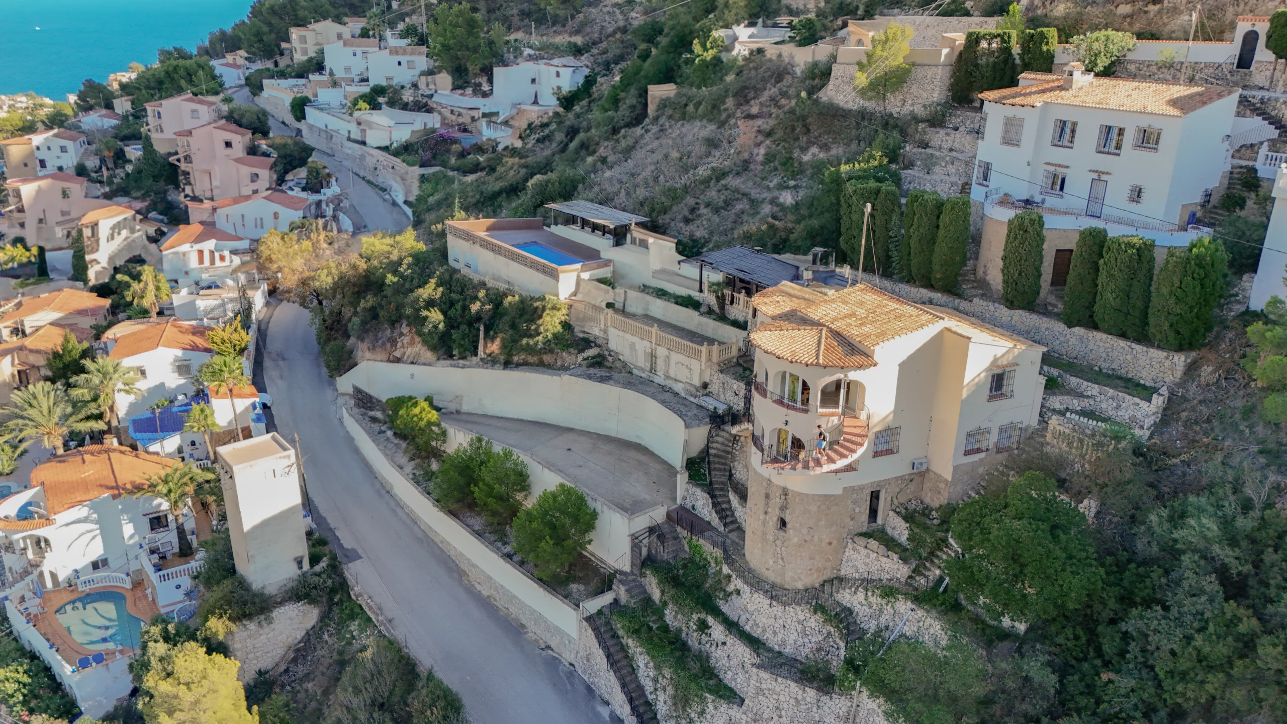 Aerial hillside street and villas overlooking the sea in Maryvilla Calpe