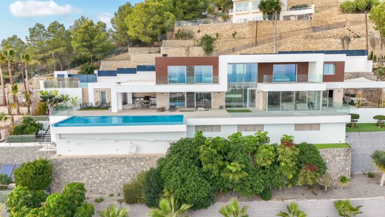 Aerial view of modern luxury villa with pool, terraces, and landscaped gardens in Calpe