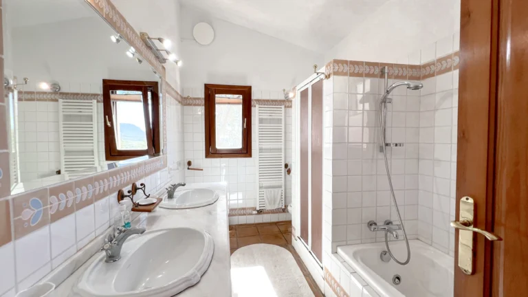 Bathroom with double sinks and bathtub in rustic Benissa home