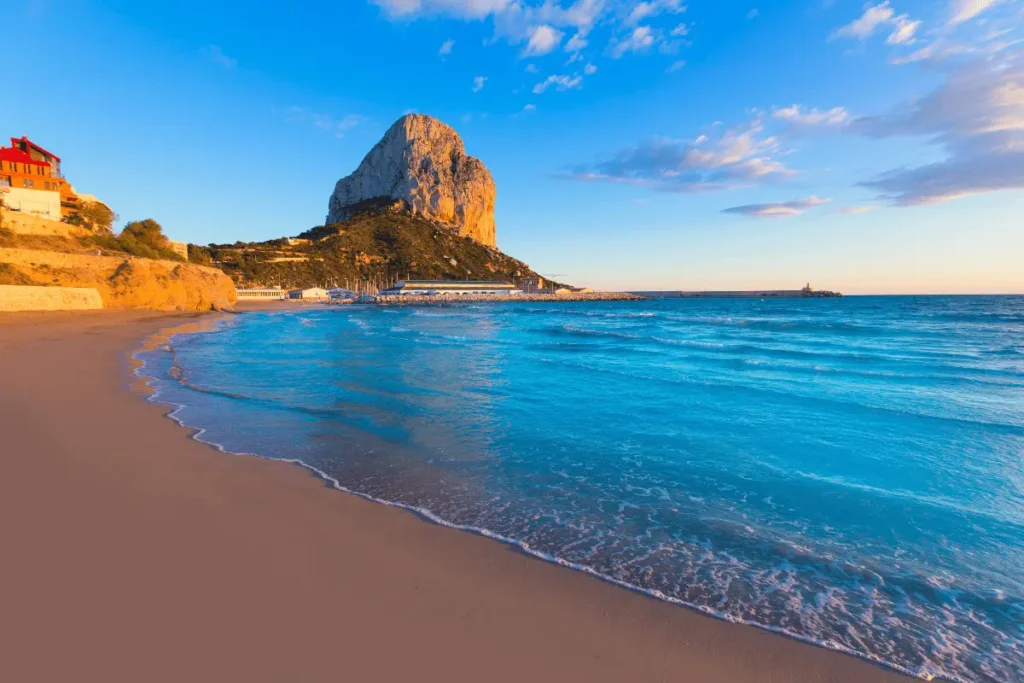 Golden sunset at Playa Cantal Roig beach in Calpe with views of the Peñón de Ifach.