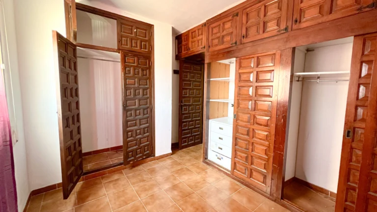 Bedroom with built-in wooden wardrobes needing renovation in Calpe