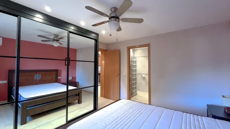 Bedroom with mirrored wardrobe and ceiling fan in Maryvilla Calpe villa