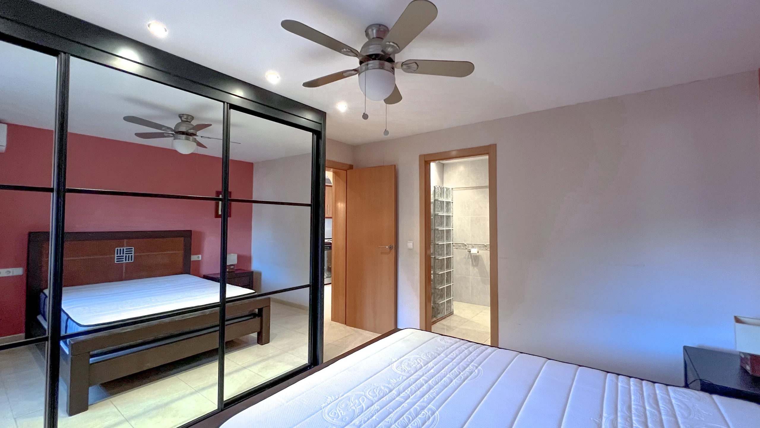 Bedroom with mirrored wardrobe and ceiling fan in Maryvilla Calpe villa