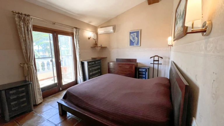 Bedroom with wooden furniture and terrace access in Benissa countryside finca