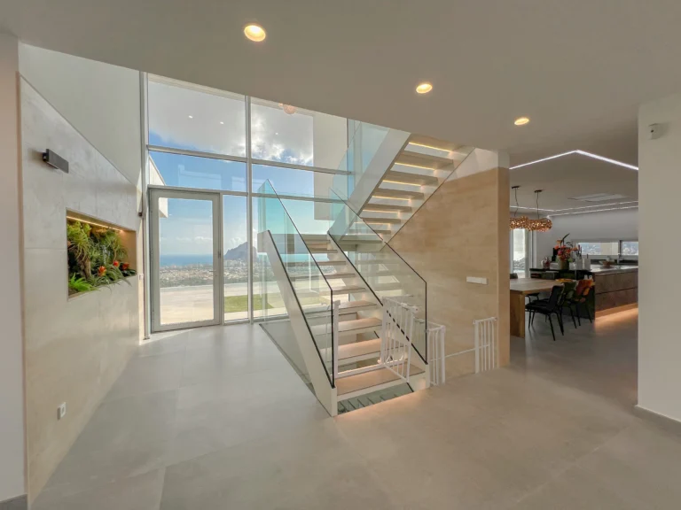 Bright interior with glass staircase and sea views inside a luxury villa in Calpe
