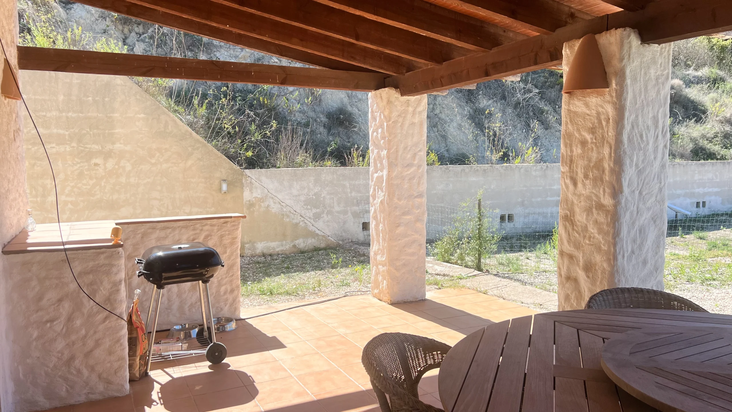 Covered barbecue terrace with a wooden roof in a country finca