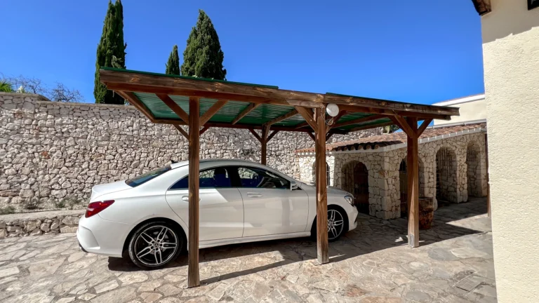 Covered carport parking with stone driveway at rustic finca in Benissa