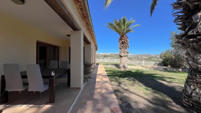 Covered outdoor dining terrace overlooking spacious garden in Benissa