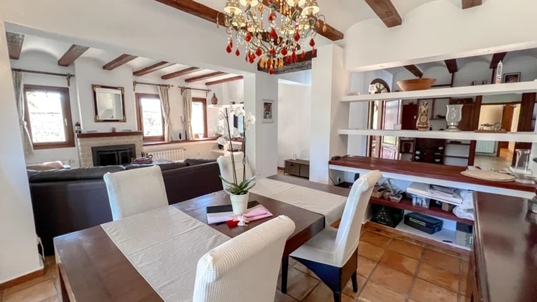 Dining area with chandelier and rustic beams inside Benissa countryside finca