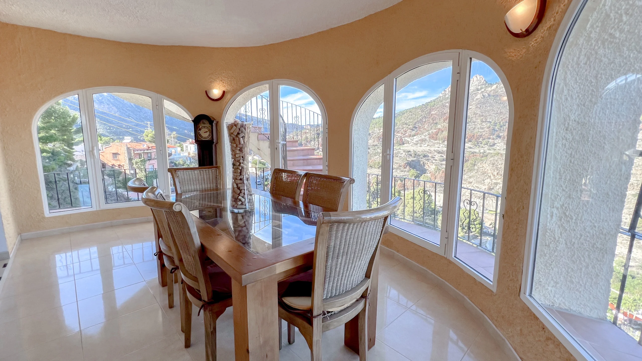 Dining room with wraparound arched windows and panoramic mountain views