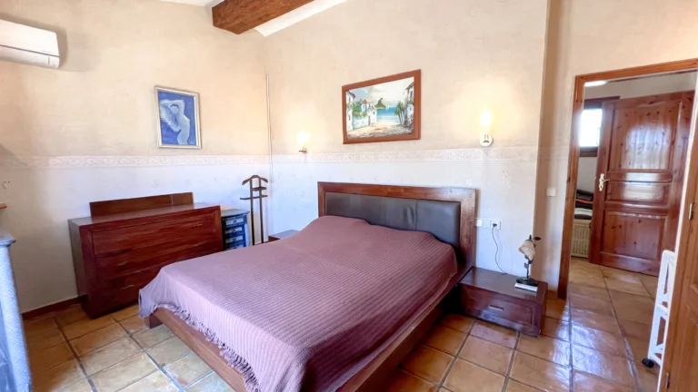 Double bedroom with wooden beams and tiled floors in Benissa country house