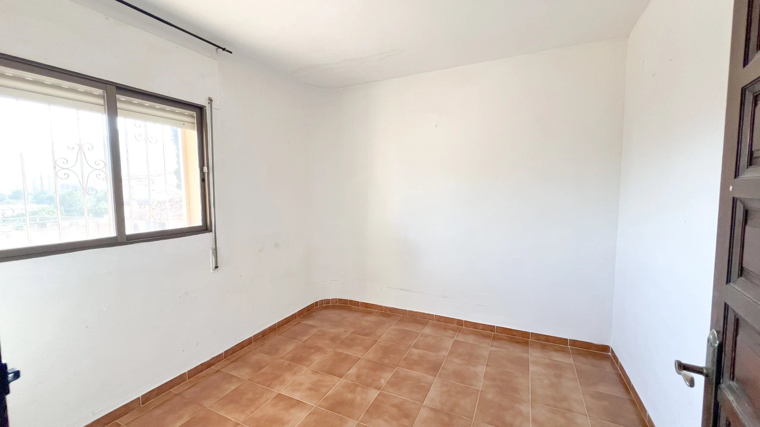 Empty bedroom with tiled floor and large window in renovation villa in Calpe