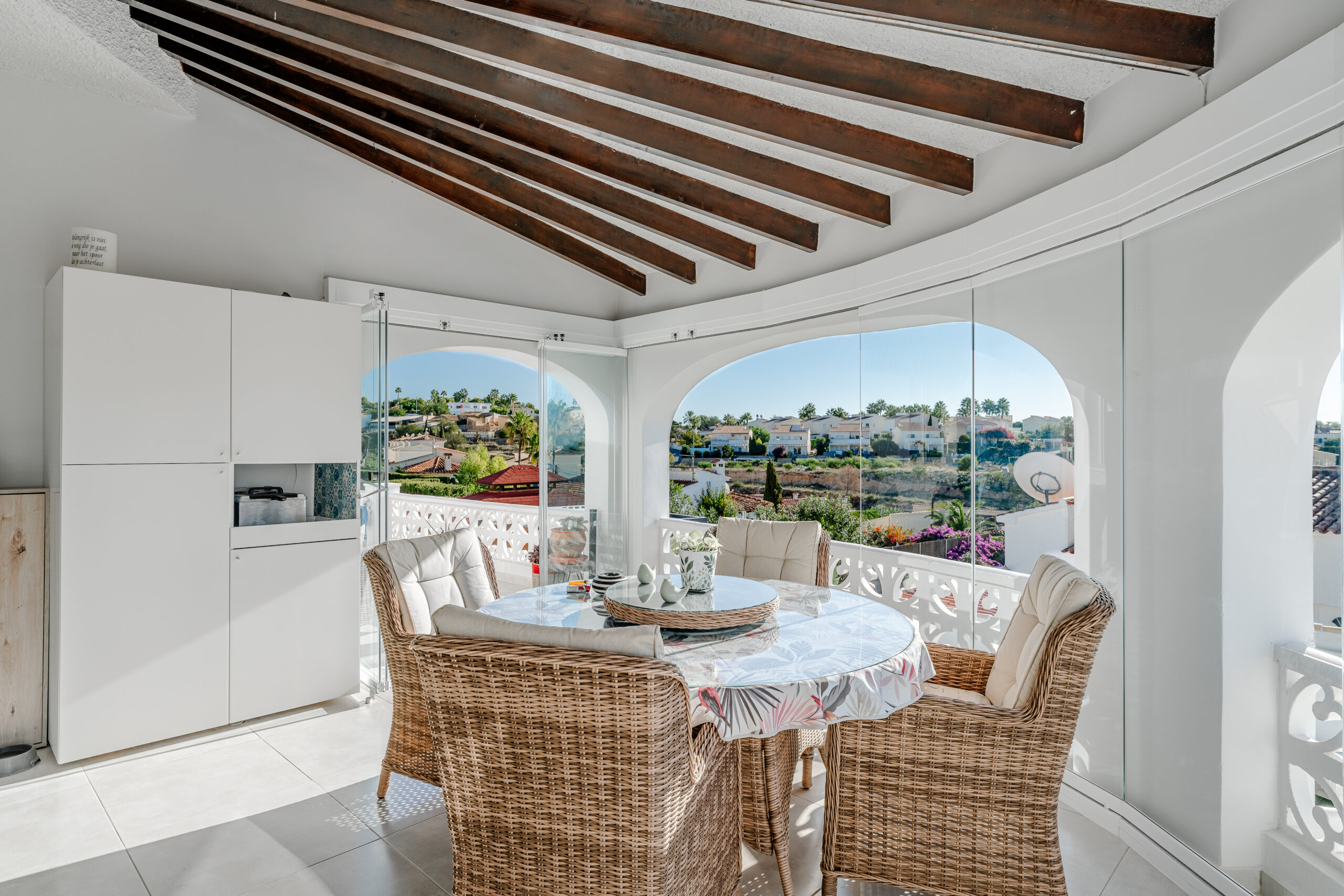 Enclosed terrace with wicker dining set and panoramic views in a Calpe villa