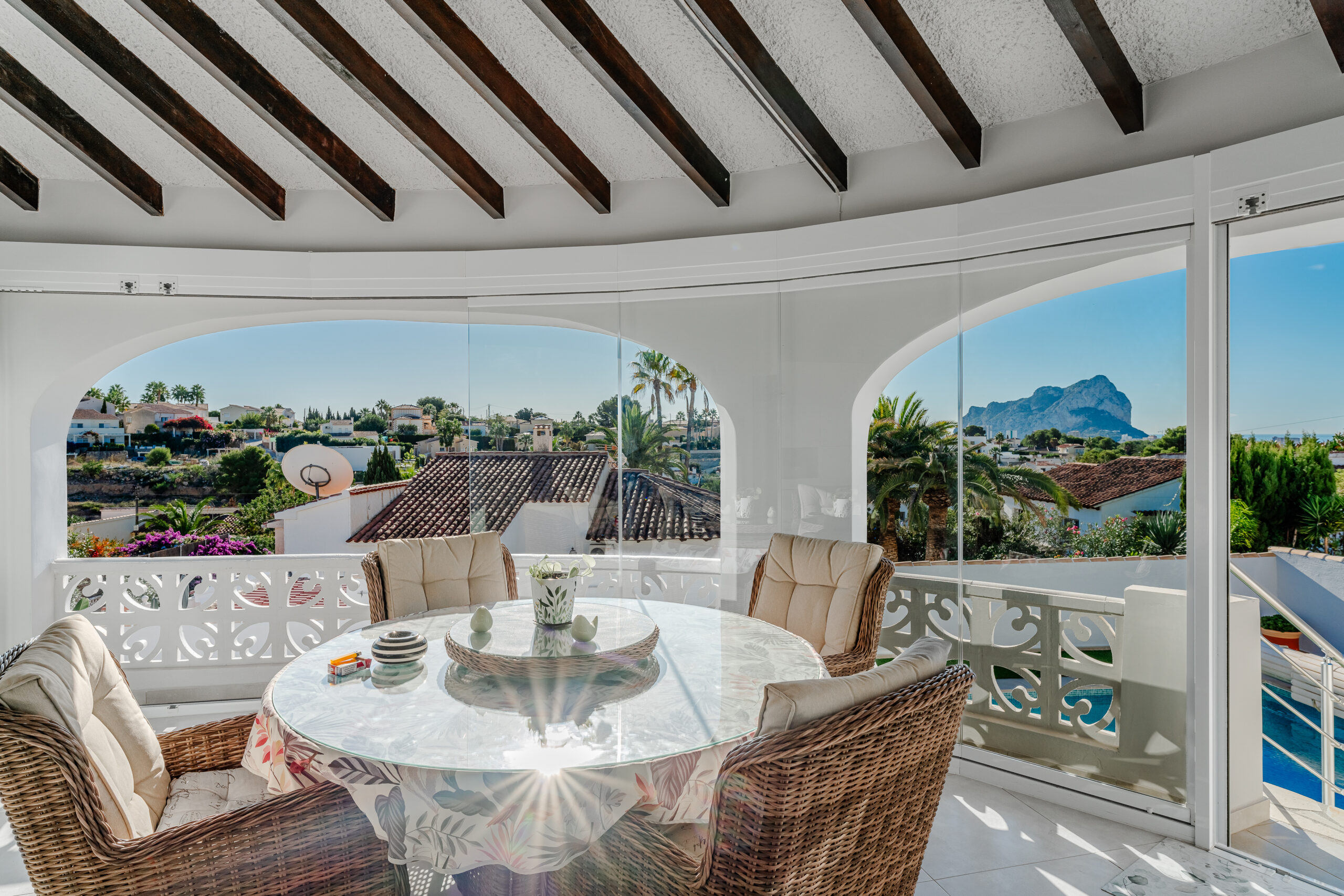Glass-enclosed terrace with dining area and sea views in Calpe