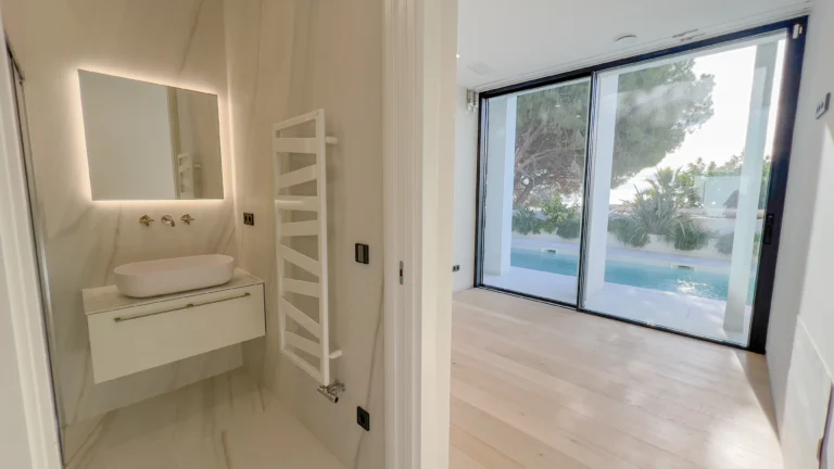 Guest bathroom with modern vanity and pool-view window in Altea villa