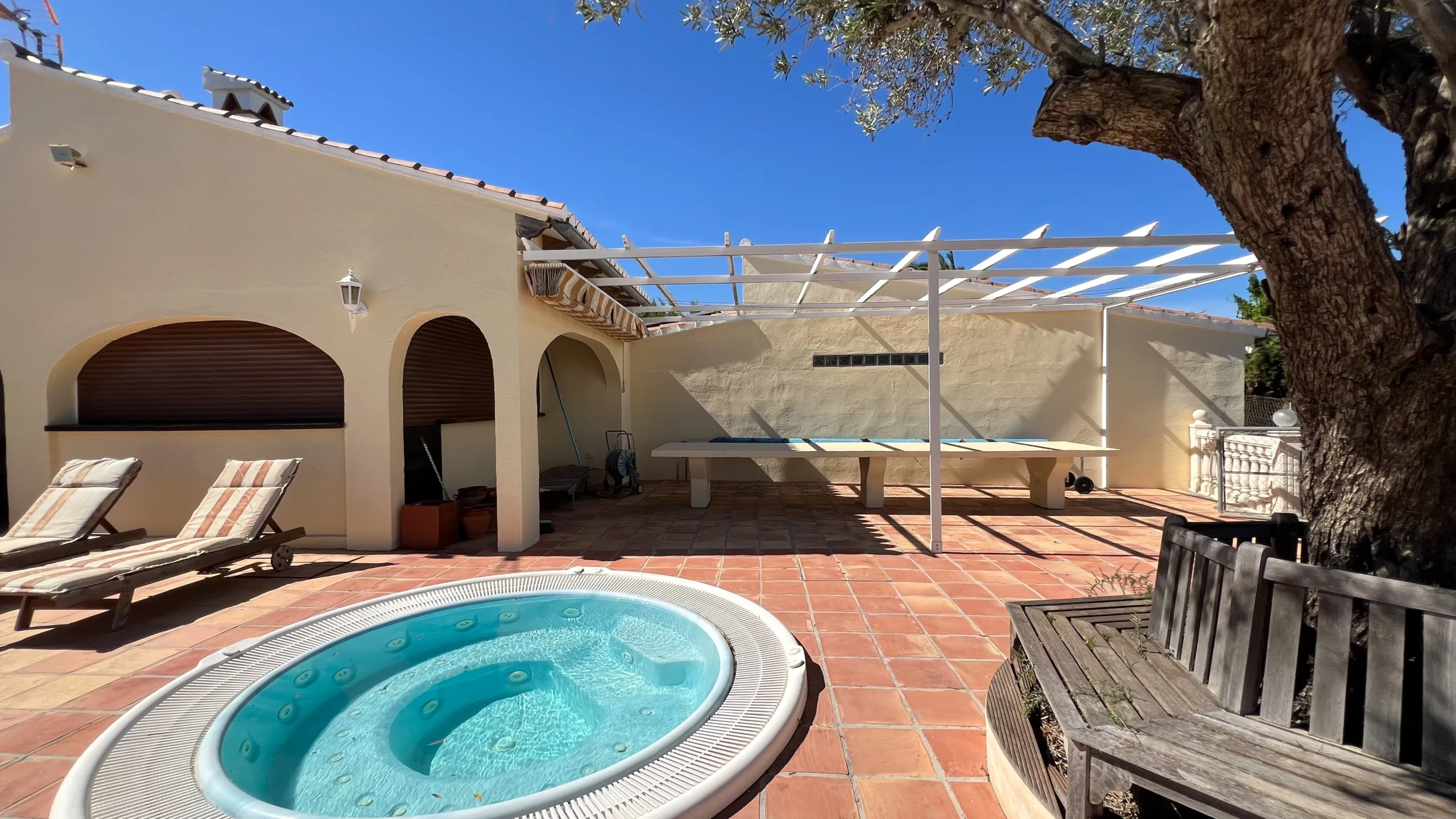 Jacuzzi and shaded terrace surrounded by olive trees at Benissa finca
