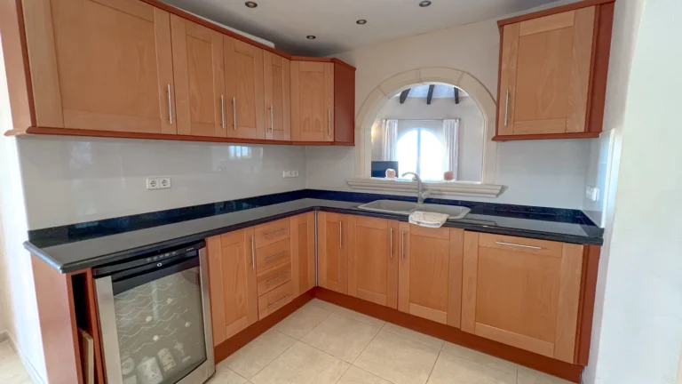 Kitchen with wooden cabinets and wine fridge in Maryvilla Calpe villa