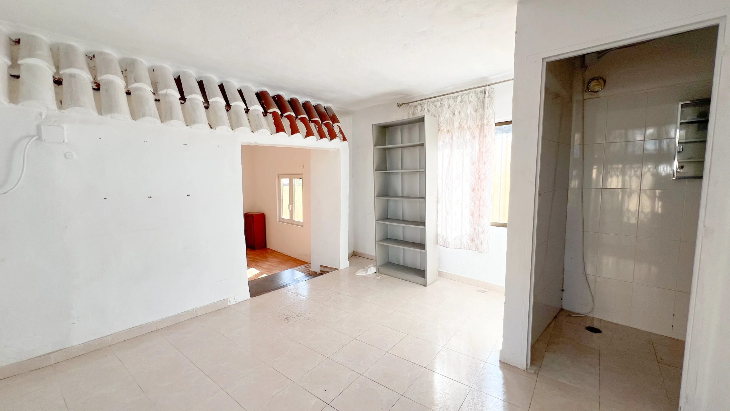 Living area with tiled floor and open kitchen space in a Calpe house to renovate