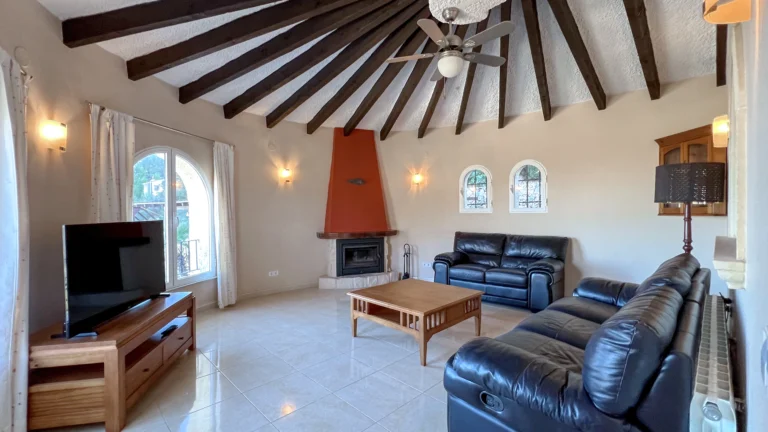 Living room with fireplace and beam ceiling in Maryvilla sea-view villa