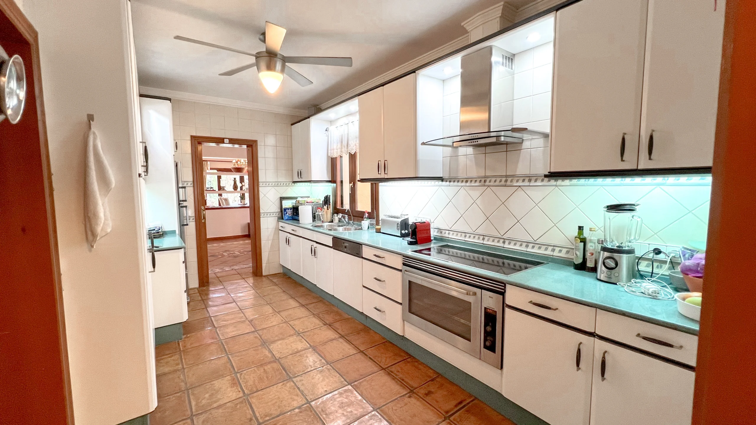 Long fitted kitchen with wooden beams and tiled floor in Benissa country villa