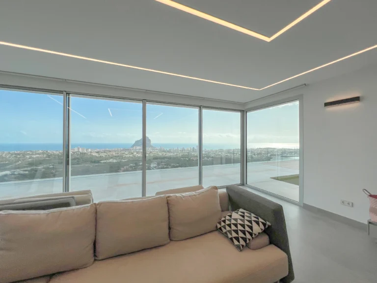 Lounge area with panoramic sea and mountain views through floor-to-ceiling windows in Calpe