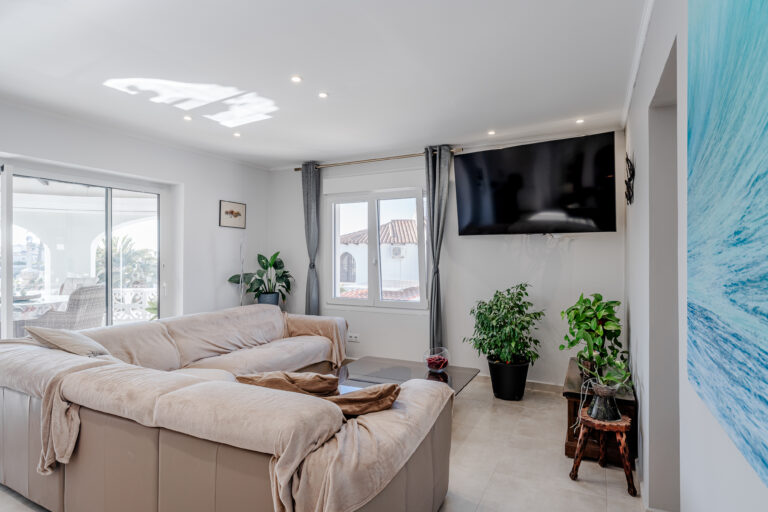Modern living room with large sofa and outdoor terrace access in a Calpe villa