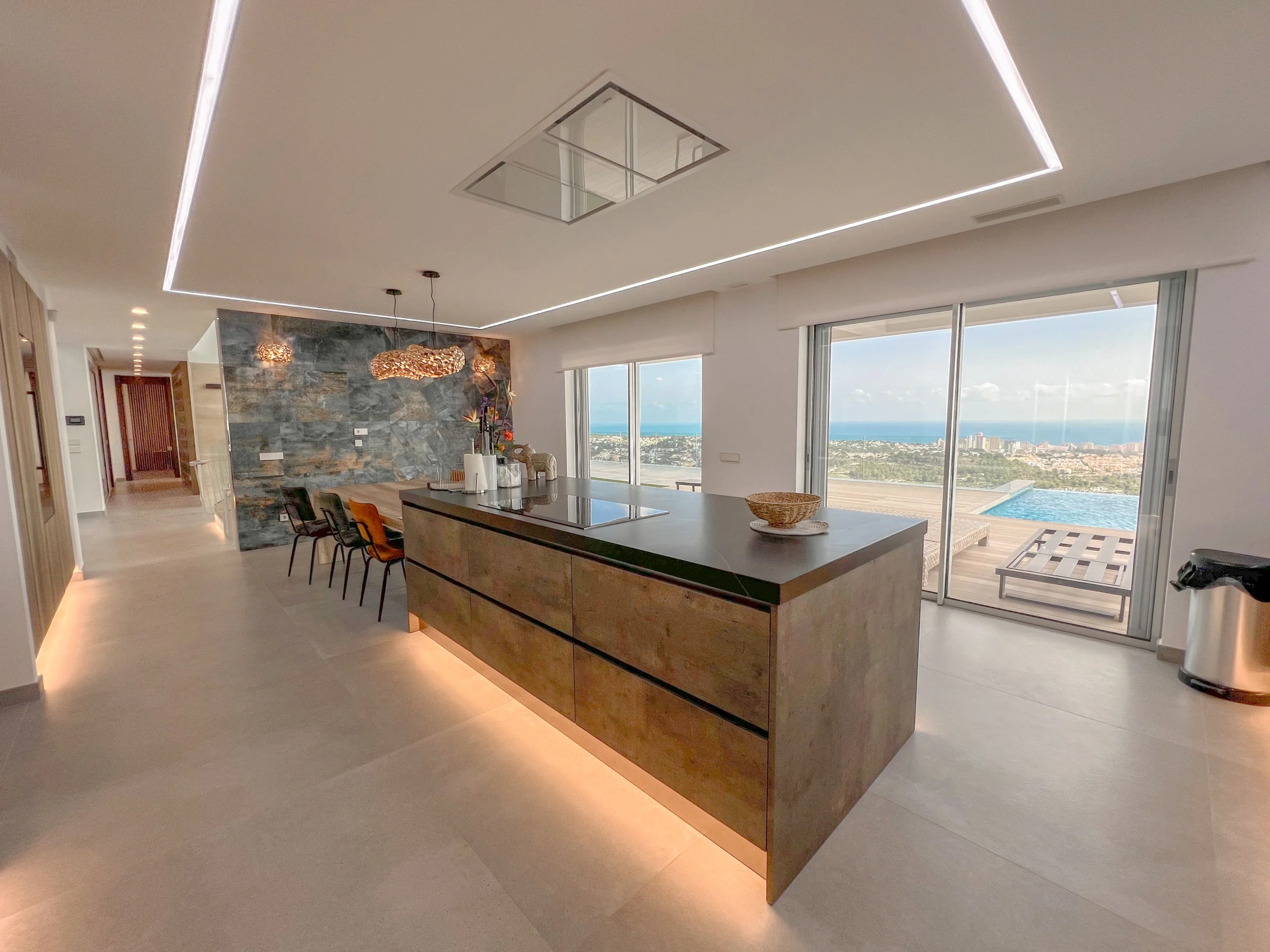 Modern open-plan kitchen and dining area with island and panoramic sea views in Calpe