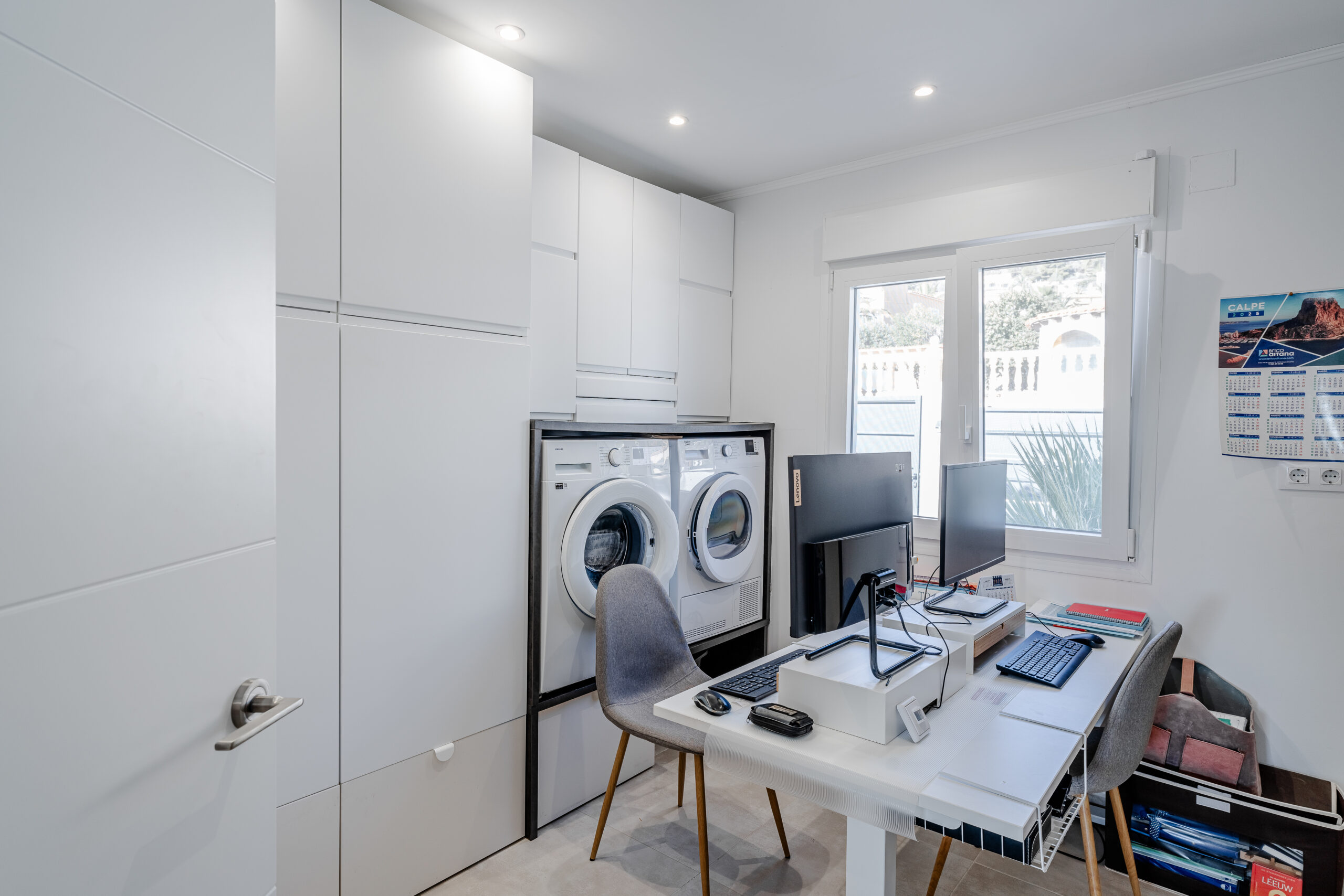 Multipurpose laundry room and home office with washer, dryer and desk in a Calpe villa