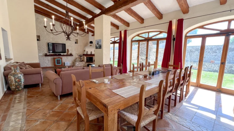Open-plan dining and seating area with chandelier and countryside views in Benissa finca