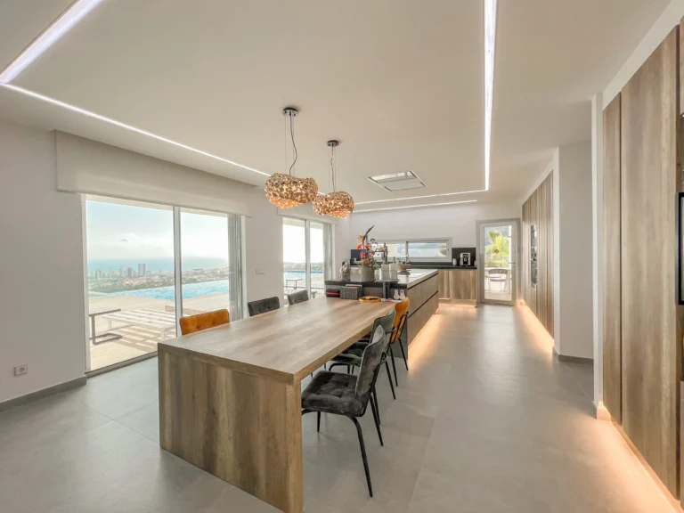 Open-plan kitchen and dining room with sea-view windows in a modern Calpe villa