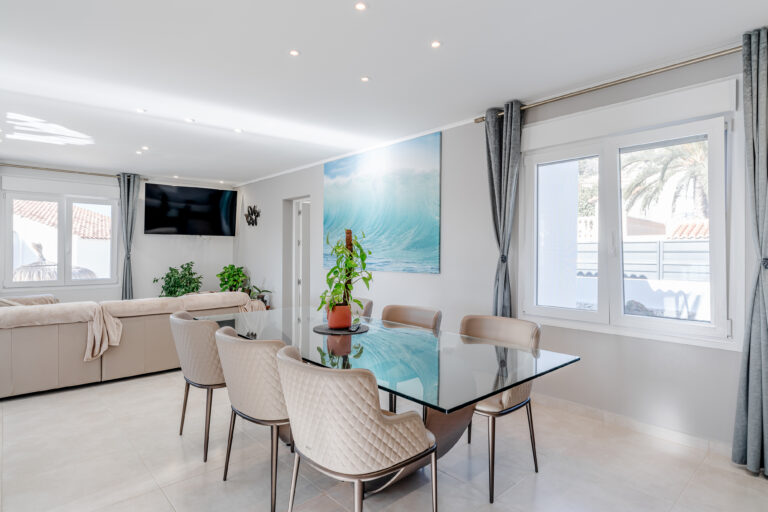Open-plan living and dining room with large windows in a Calpe villa
