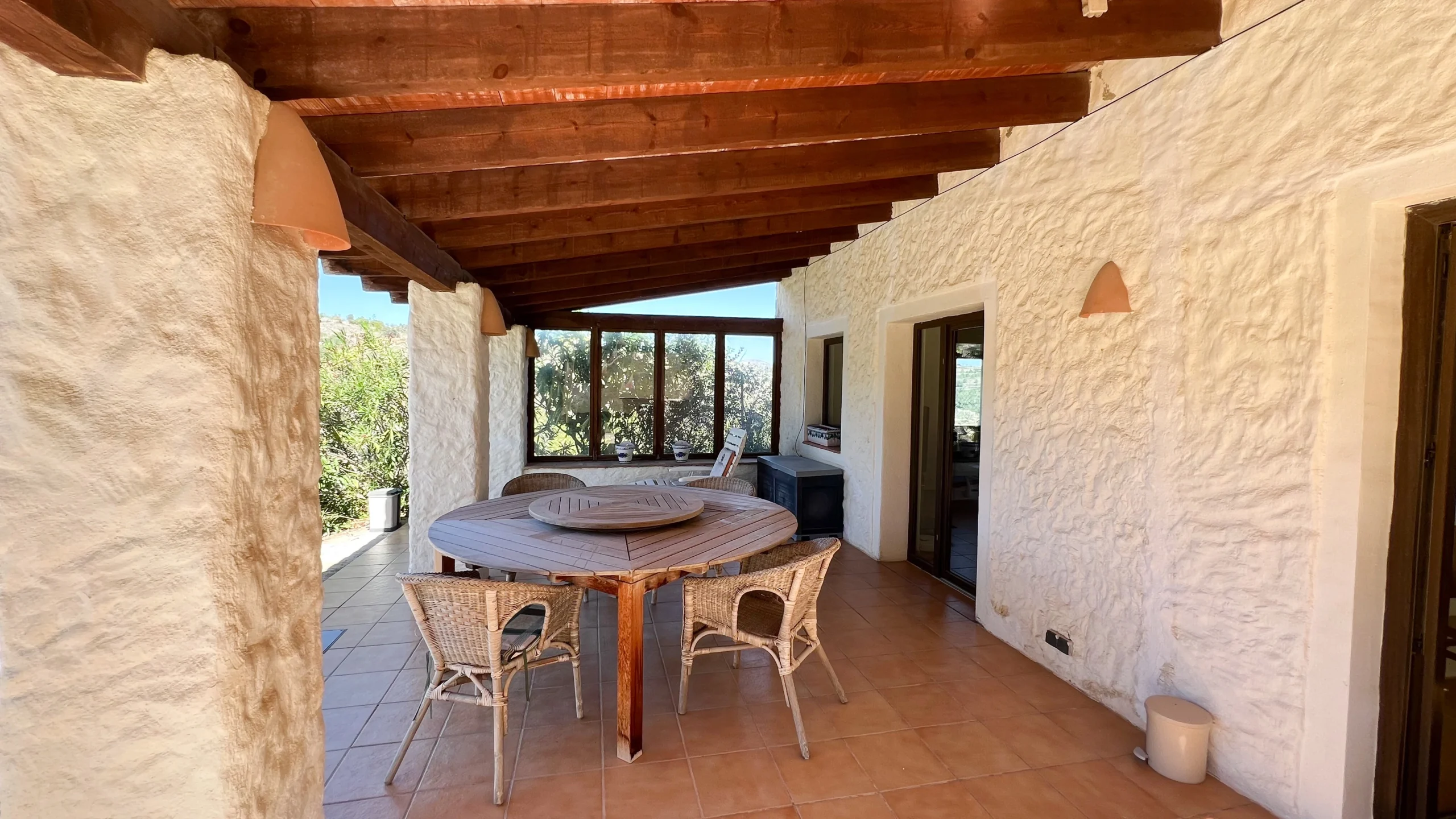 Outdoor dining area under a rustic stone-finished porch in Benissa Pueblo