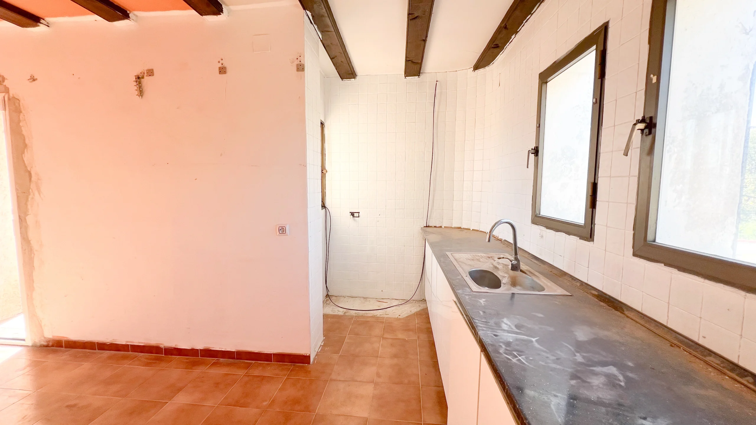 Partially renovated kitchen with countertops and windows in Calpe property