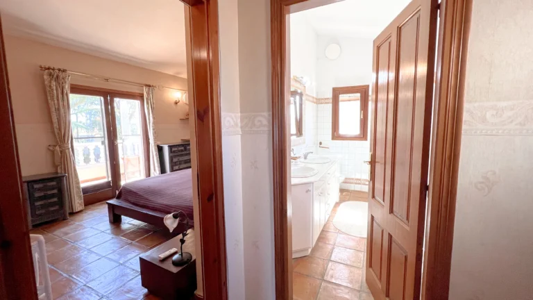 Primary bedroom leading into ensuite bathroom in rustic Benissa villa