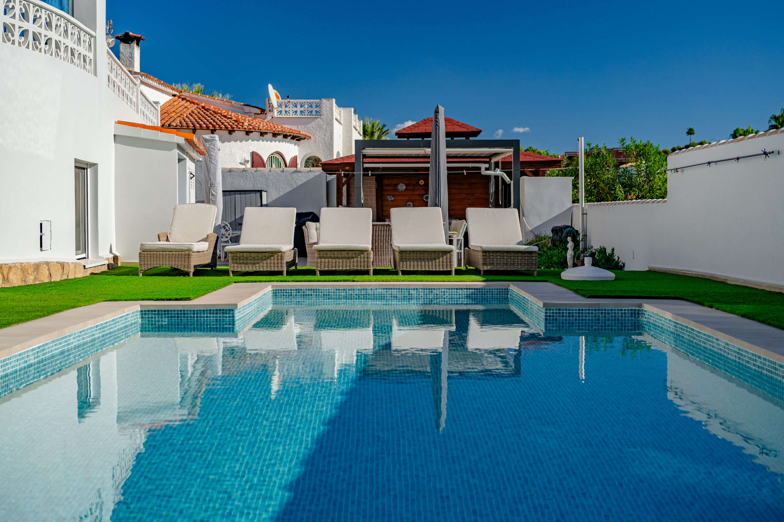 Private pool terrace with sun loungers beside a modern villa in Calpe