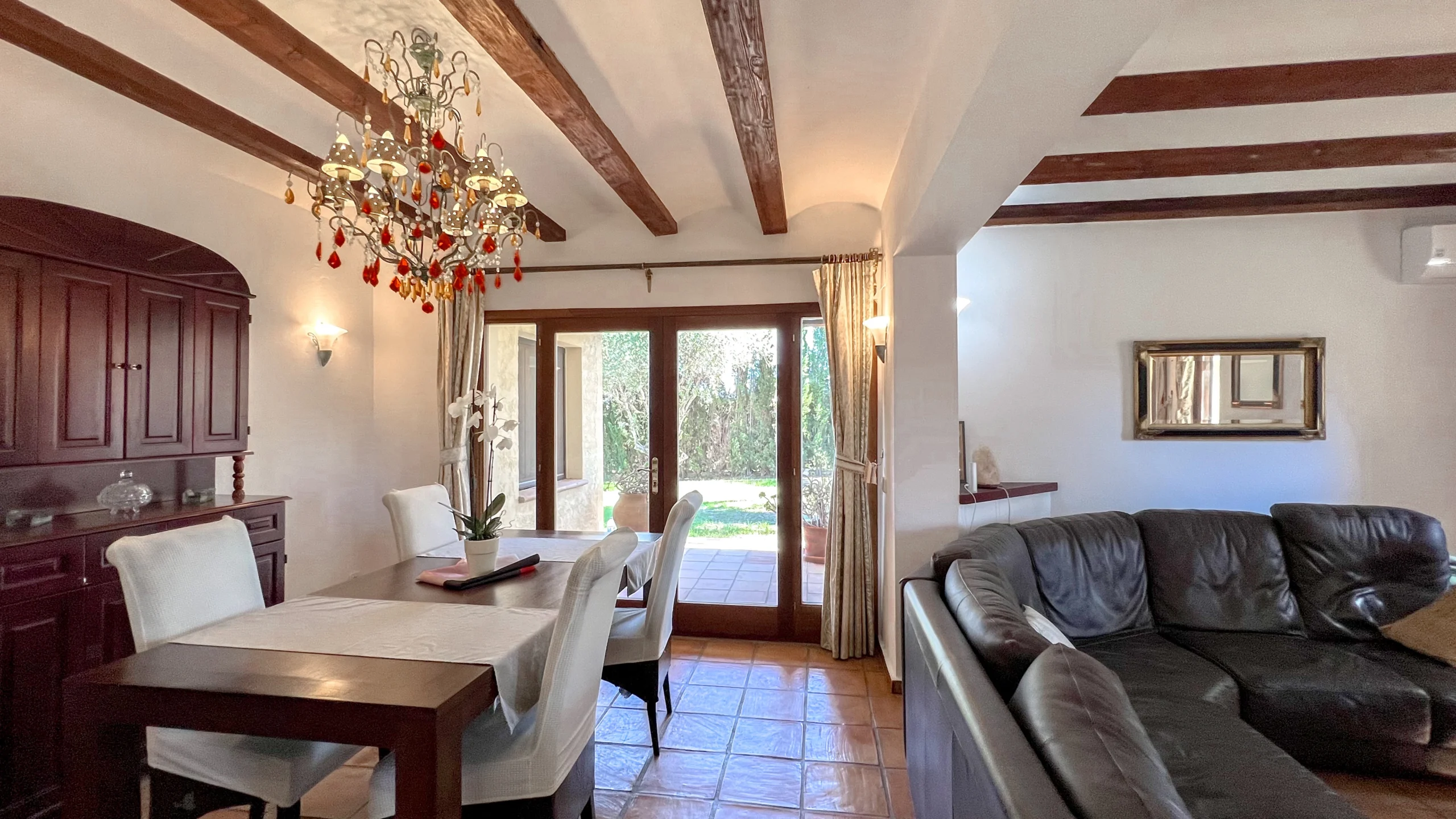 Rustic dining room with wooden furniture and garden access in Benissa countryside home