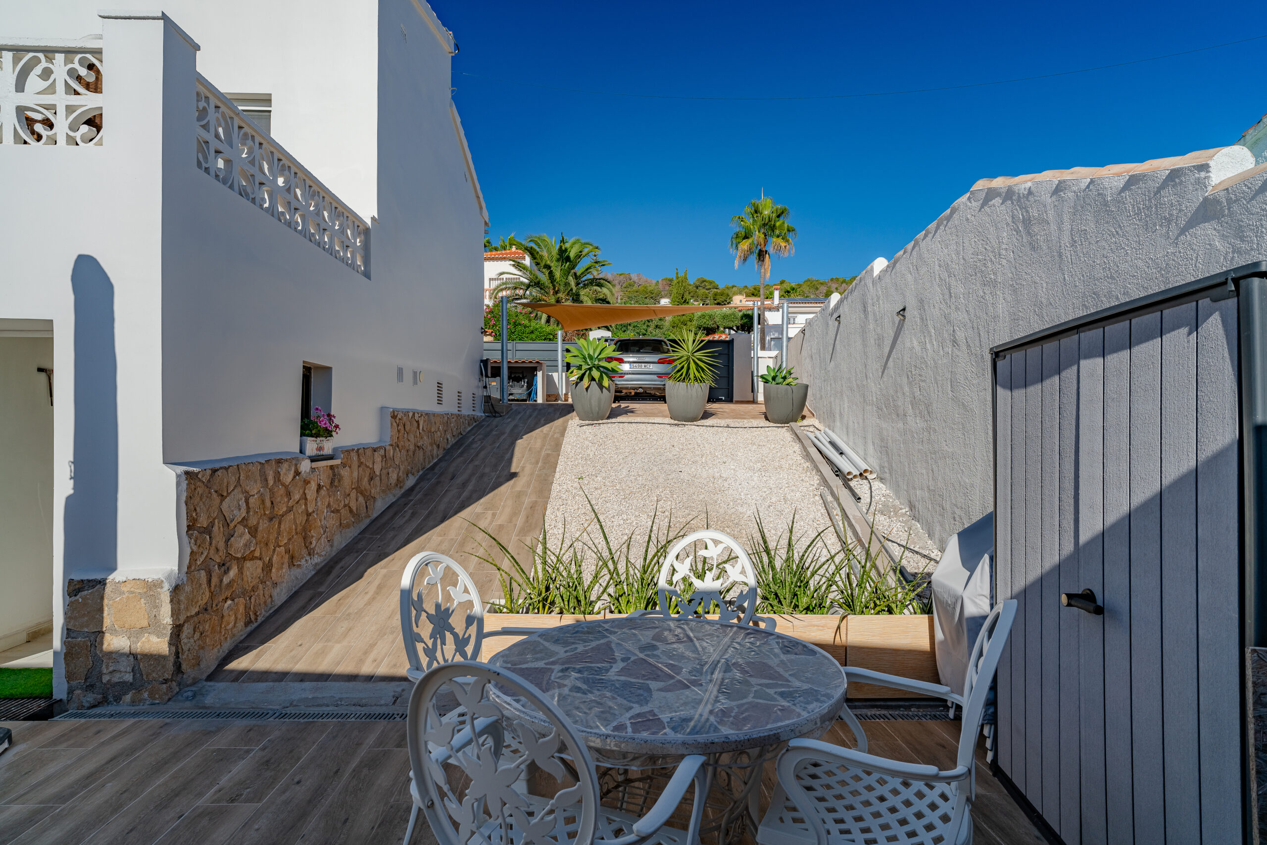 Small terrace with white outdoor dining set and garden access in a Calpe villa
