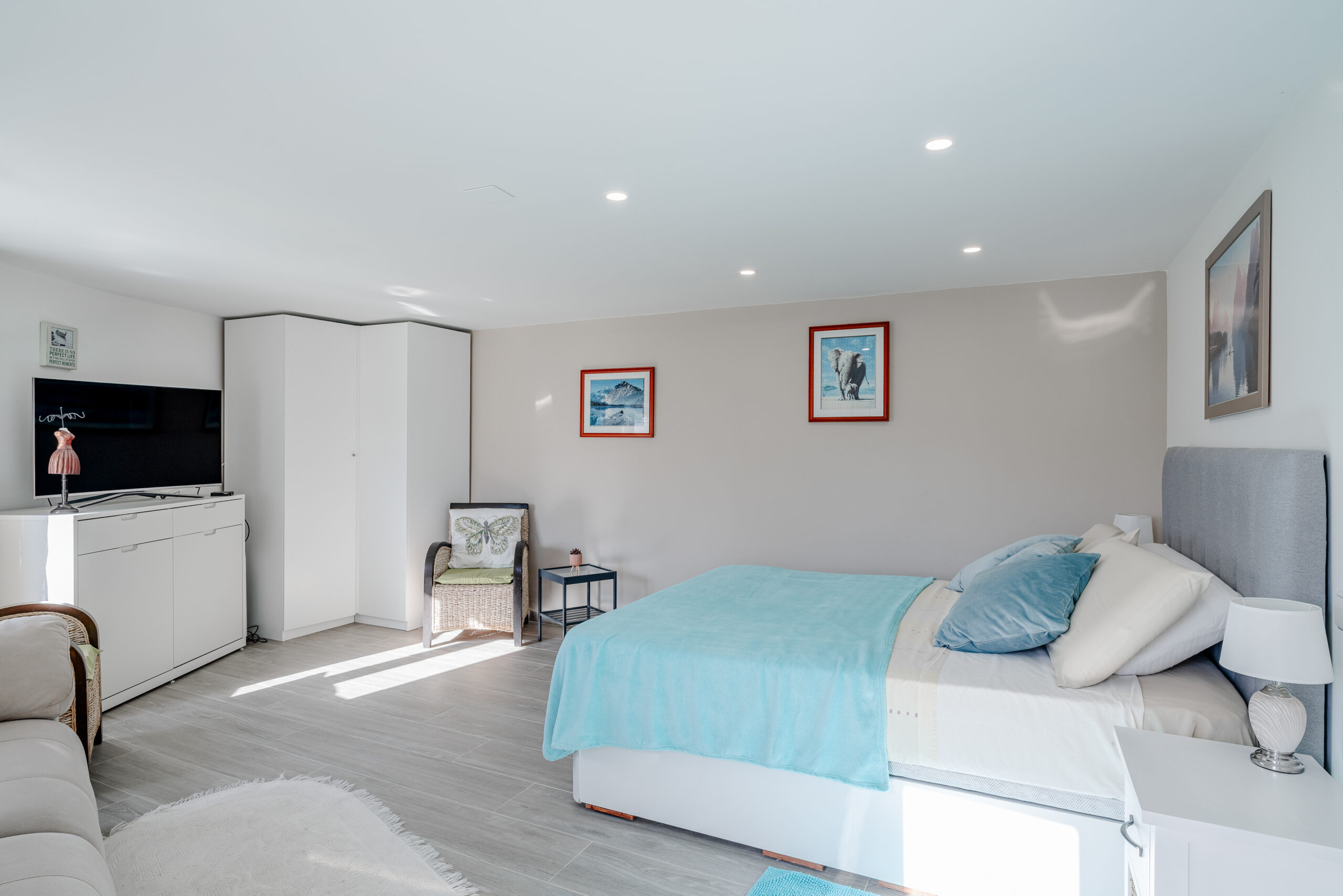 Spacious guest apartment bedroom with seating area and large windows in a Calpe villa