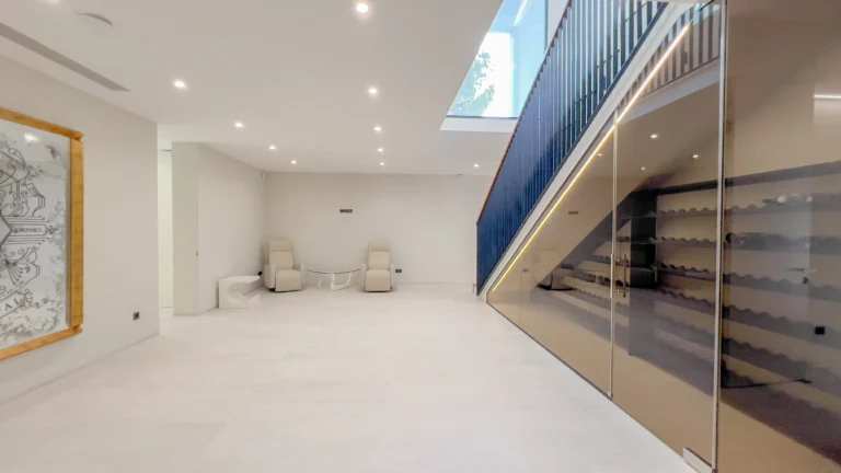 Spacious lower-level lounge with skylight and modern staircase in Altea villa