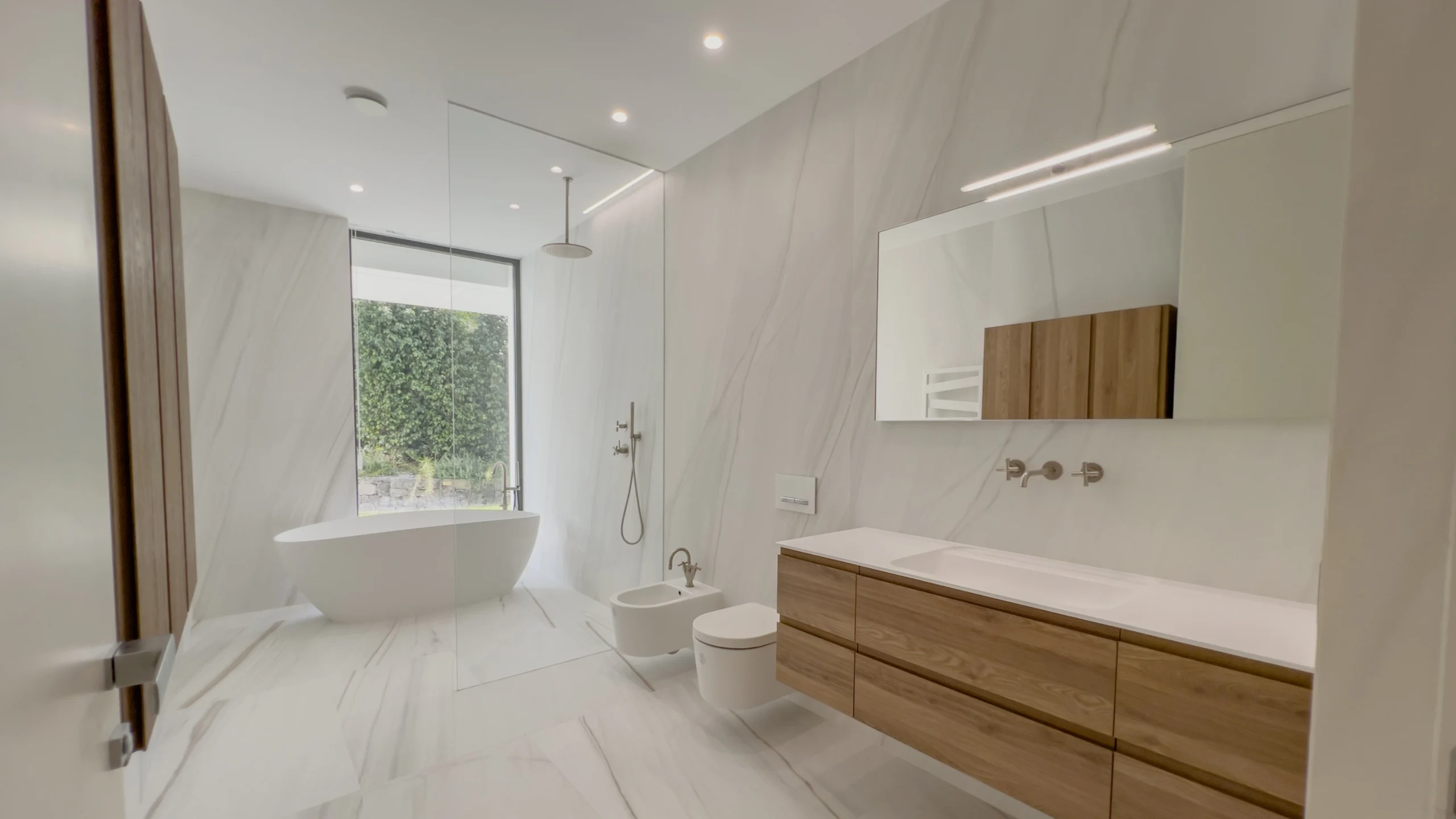 Spacious luxury bathroom with freestanding tub and garden views in Altea