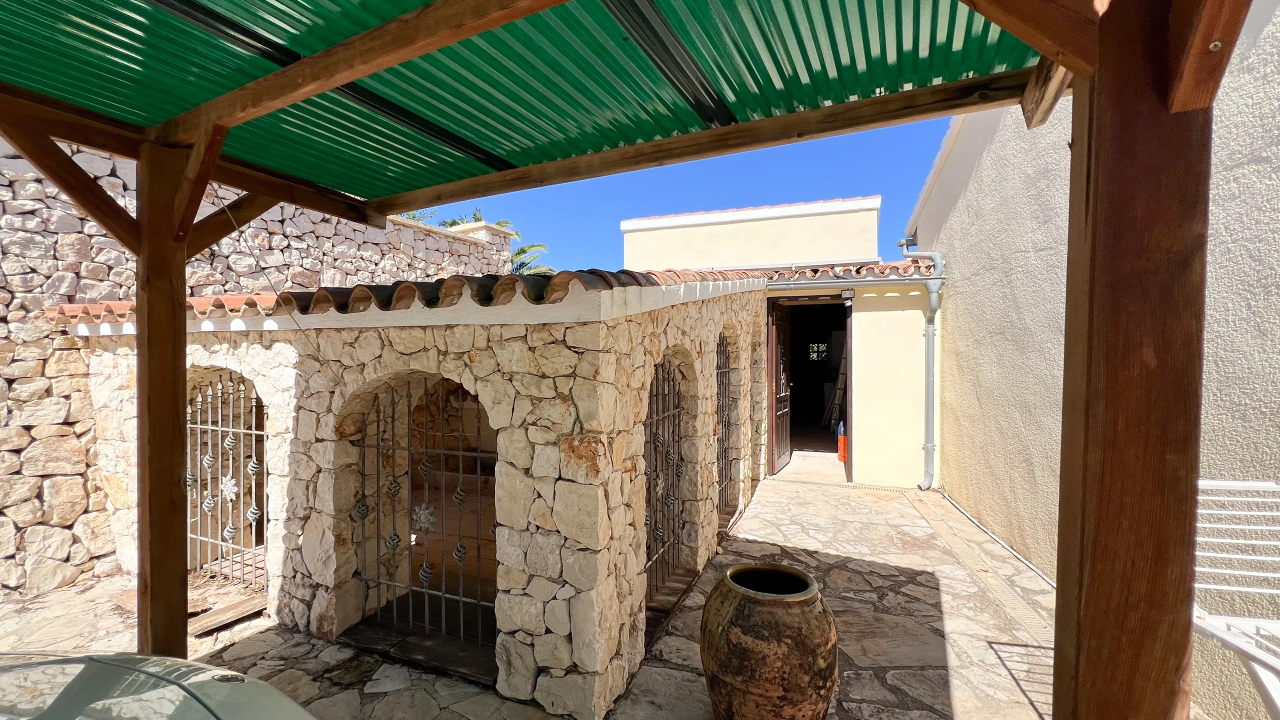 Stone storage building and shaded patio in a rustic Benissa property