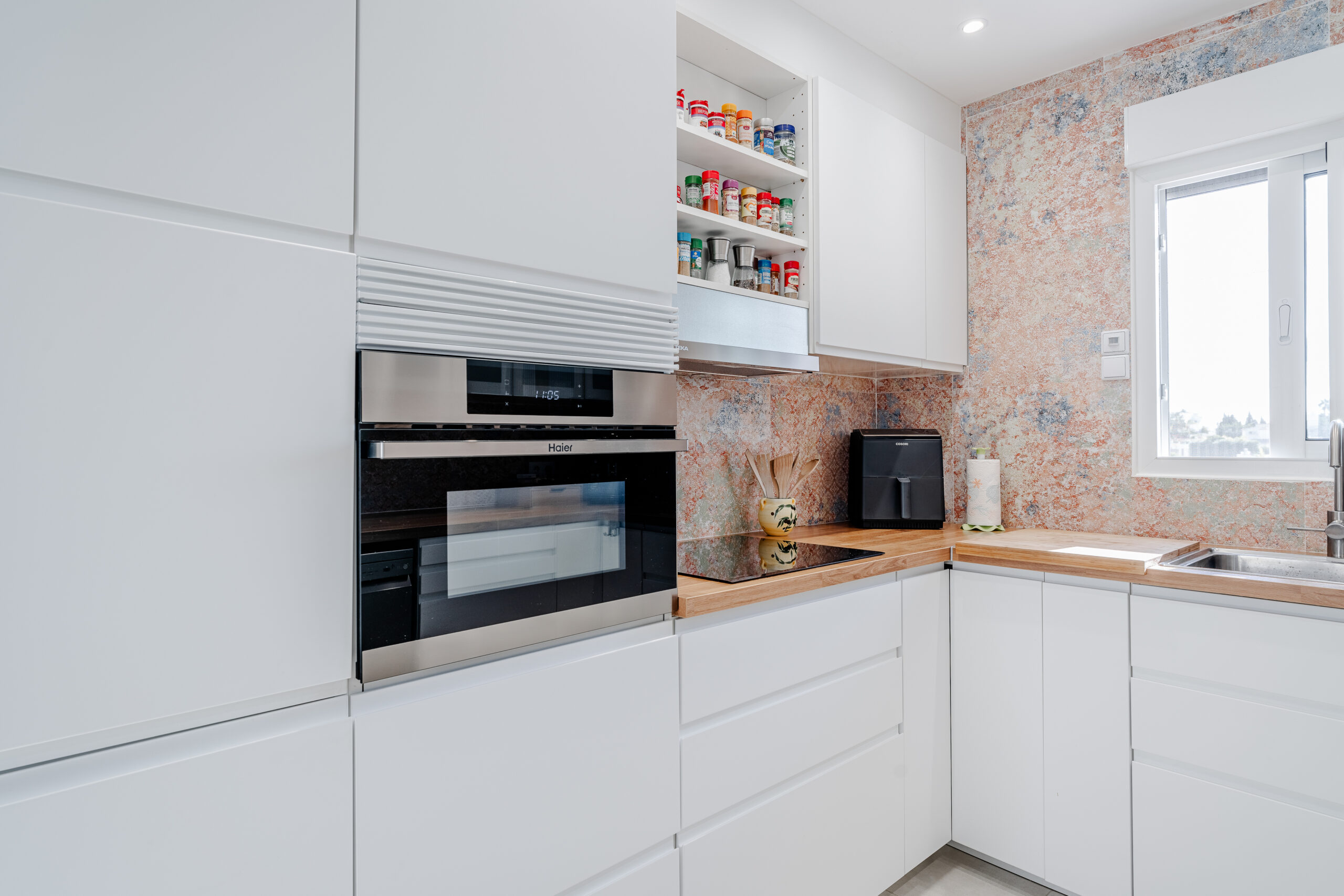 White kitchen with integrated oven and storage in a renovated villa in Calpe