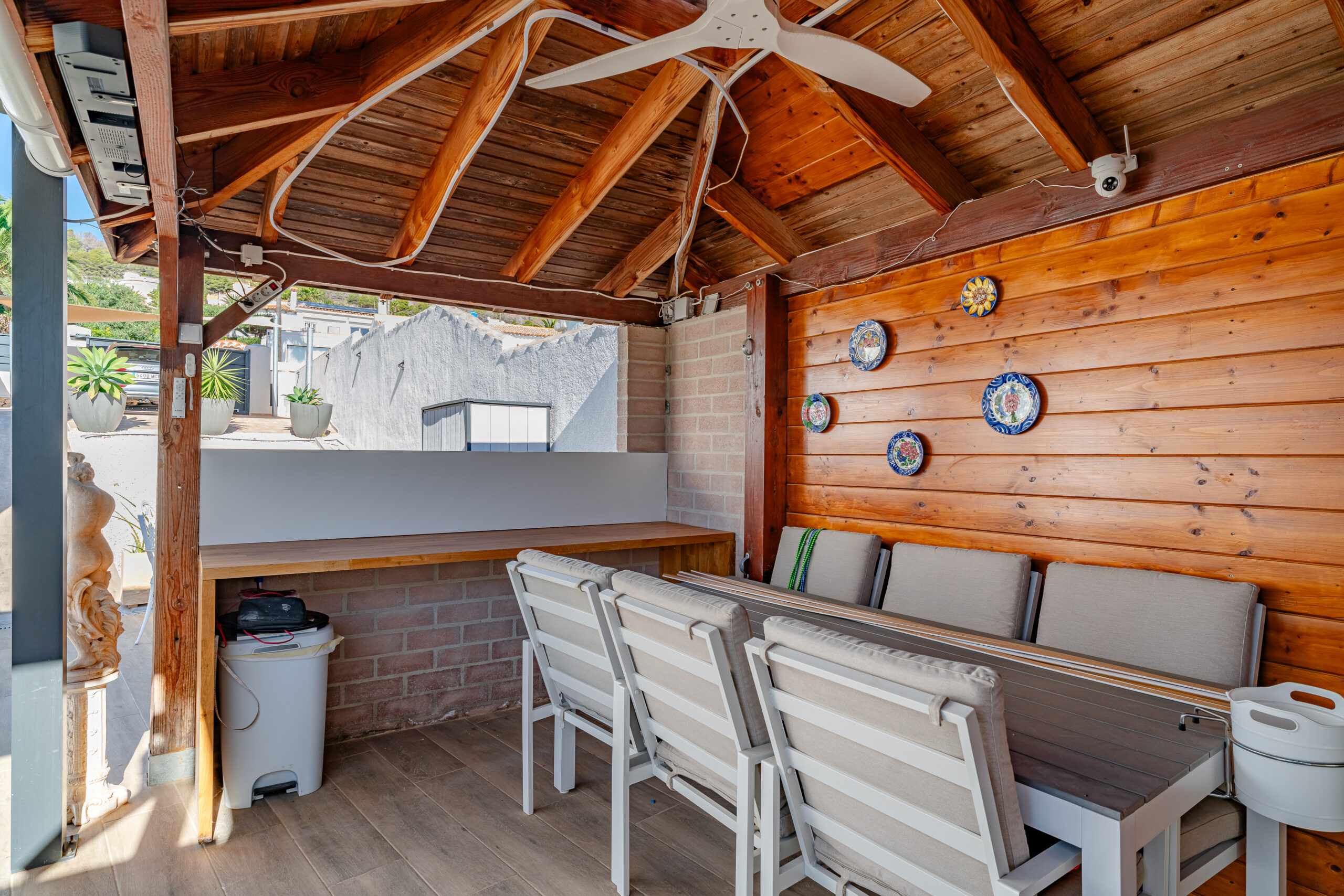 Wooden-covered outdoor dining area with bar-style seating in a Mediterranean villa