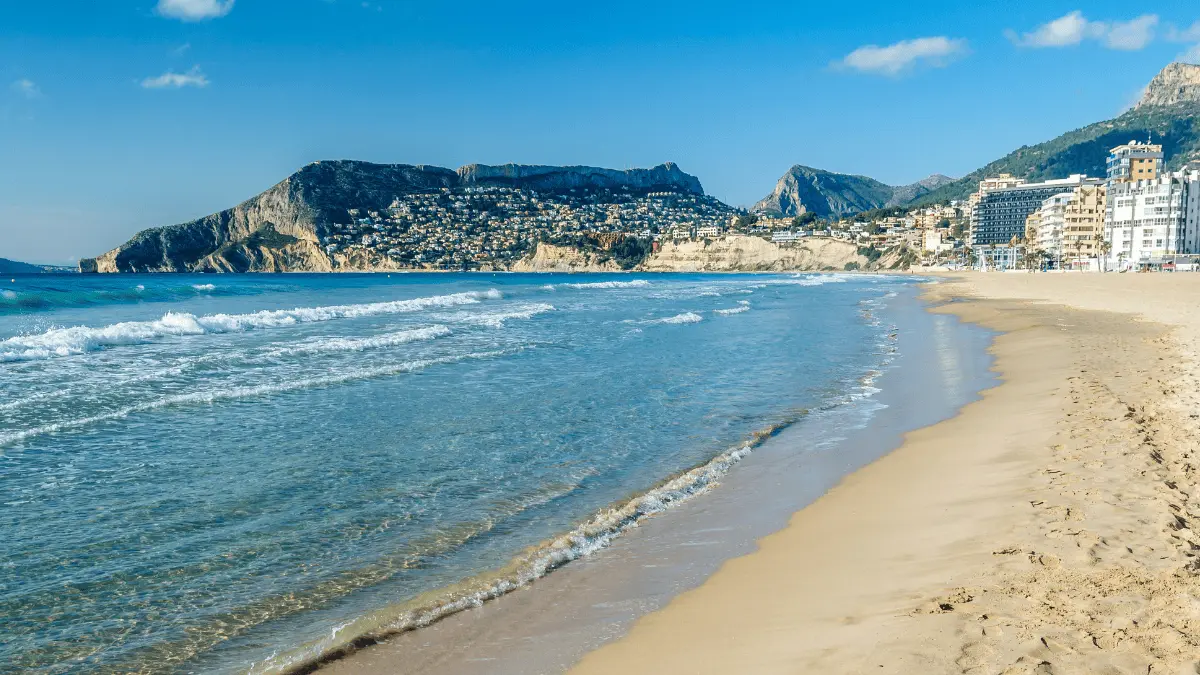 Beach and Mediterranean coastline in Calpe near Maryvilla with mountain backdrop and seafront buildings