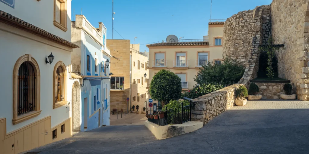 Ancient stone city walls and Iglesia Antigua tower in Calpe Old Town, Costa Blanca Spain
