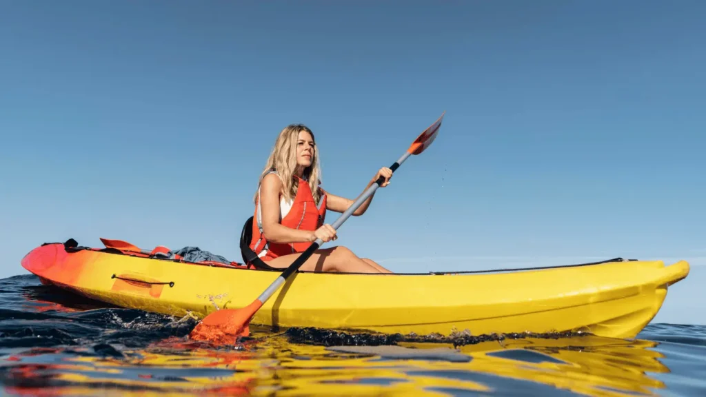 Woman kayaking in clear Mediterranean water near the beaches in Calpe, Costa Blanca
