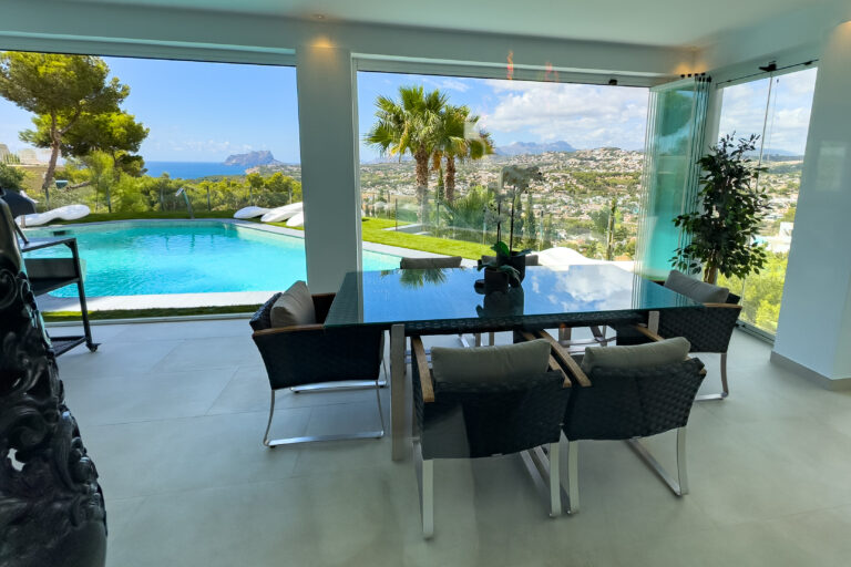Covered terrace dining area overlooking the pool at a villa in Moraira