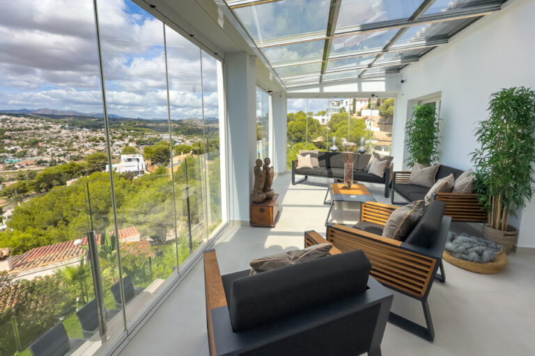 Glazed winter garden with seating and open views at a Moraira villa