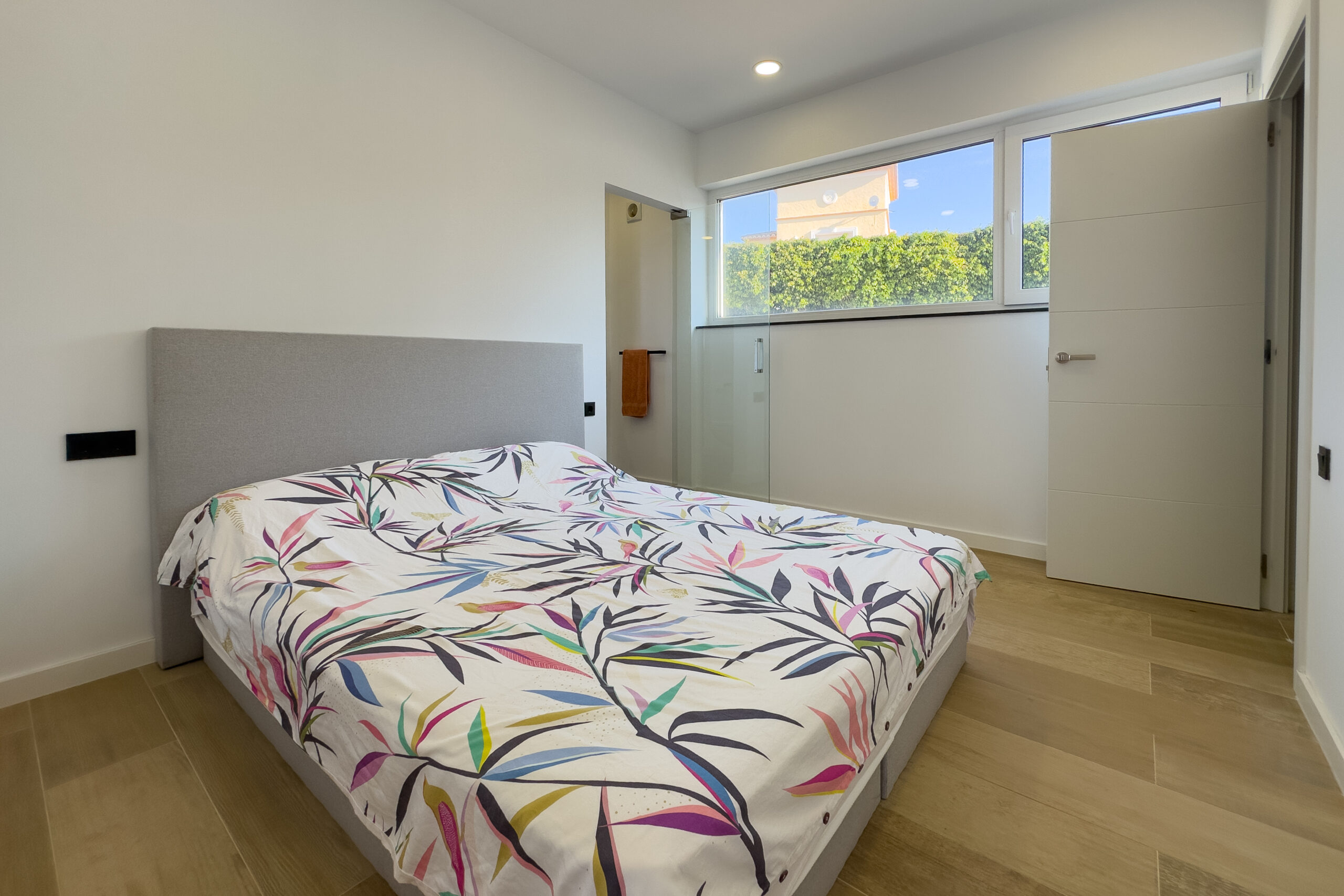 Guest bedroom with window and wood flooring in a villa in Casanova, Calpe