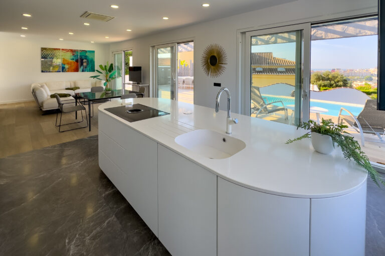 Kitchen island with large windows and pool view in a modern villa in Calpe